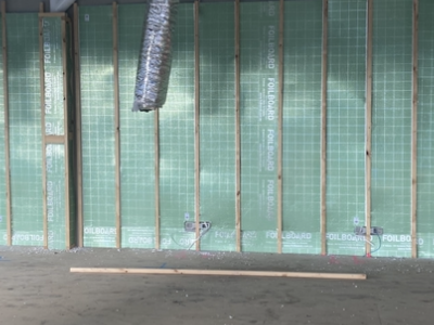 Green FoilBoard rigid panels installed on internal wall framing, ducting overhead